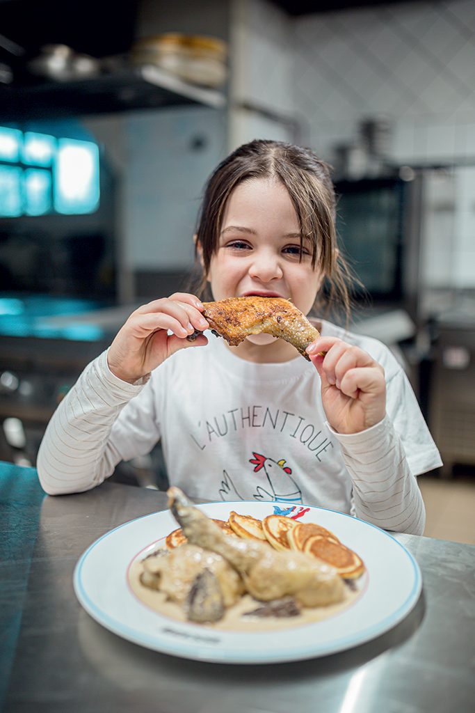 enfant qui croque une cuisse de poulet de Bresse